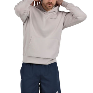 Model trekt de capuchon van de beigegrijze Bullpadel Albier hoodie omhoog