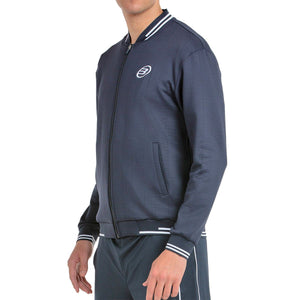 Schuin vooraanzicht van het donkerblauwe Bullpadel Jacket Trombe met rits en zakken