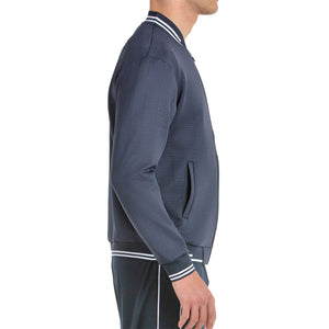 Zijaanzicht van het donkerblauwe Bullpadel Jacket Trombe met witte streep op de kraag