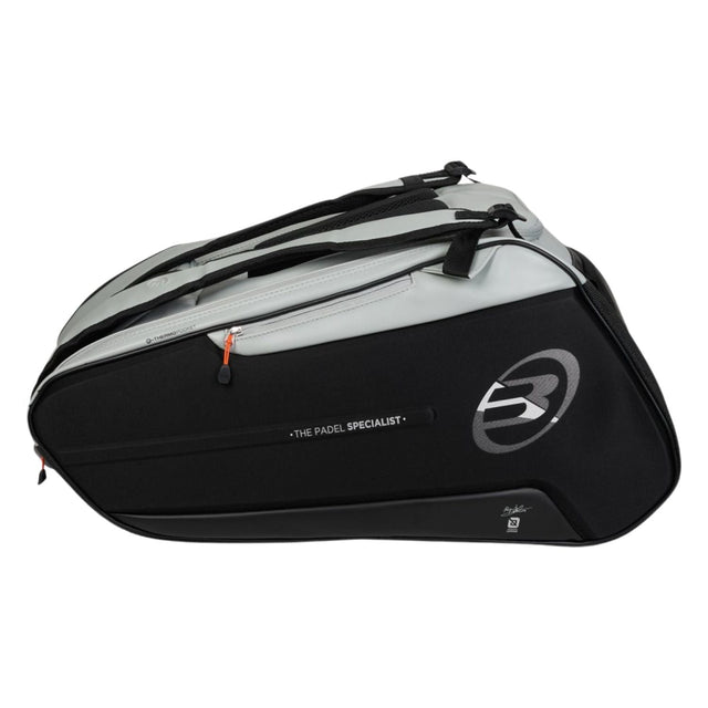 Zijaanzicht van de zwarte Bullpadel Hack 2026 racketbag met lichtgrijs bovendeel.