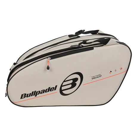 Zijaanzicht van de Bullpadel Tour 2026 in gebroken wit met koraalrode accenten en zwart logo