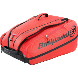 Zijaanzicht van de Bullpadel XPLO racketbag in koraalrood met zwart logo en zwarte onderzijde