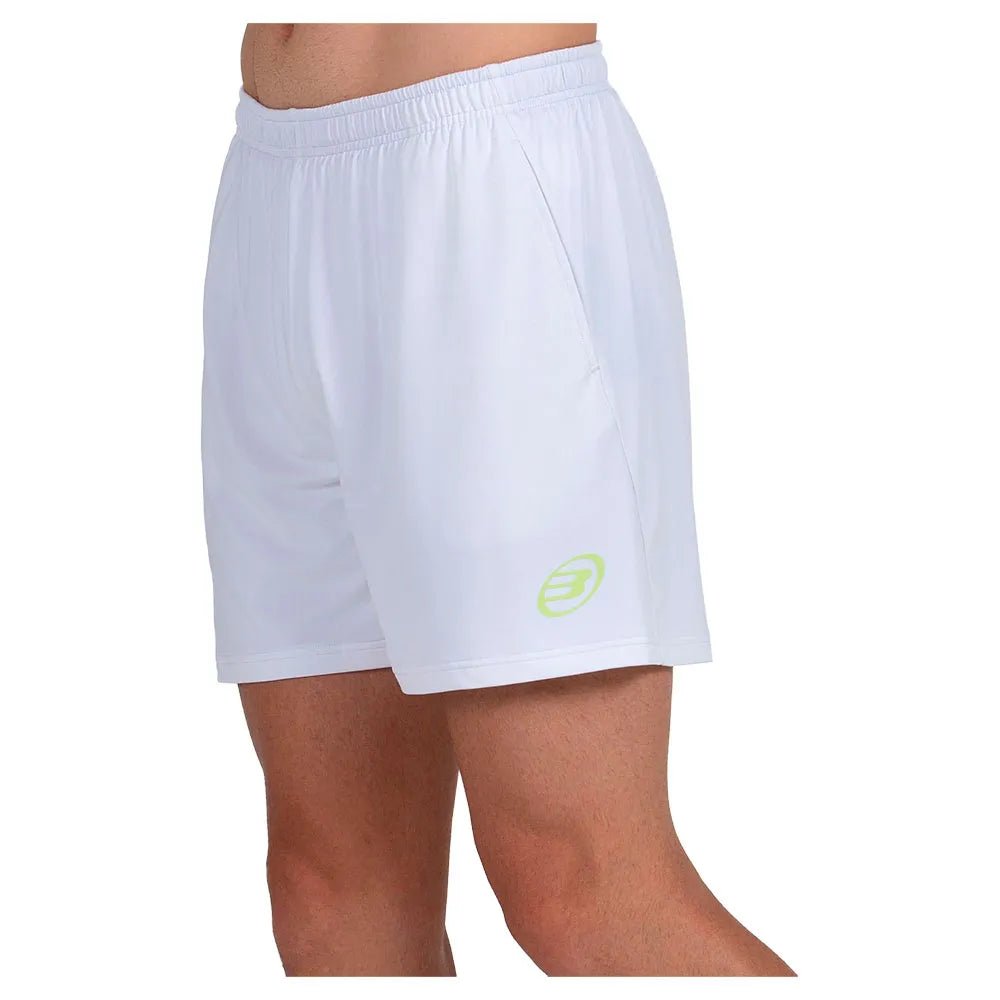 Model draagt de witte Bullpadel Short Lijar met turquoise Bullpadel-logo op de pijp