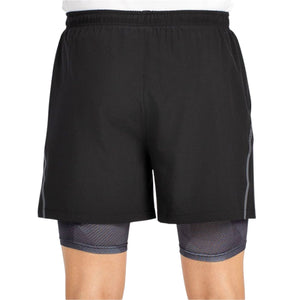 Model draagt de zwarte Bullpadel Short Manzan, schuin aanzicht met langere binnenbroek