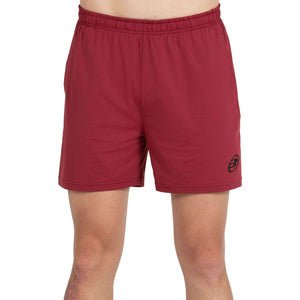 Vooraanzicht van de bordeauxrode Bullpadel Short Monfort met zwart logo op de pijp
