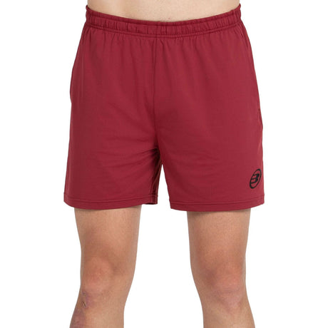 Vooraanzicht van de bordeauxrode Bullpadel Short Monfort met zwart logo op de pijp