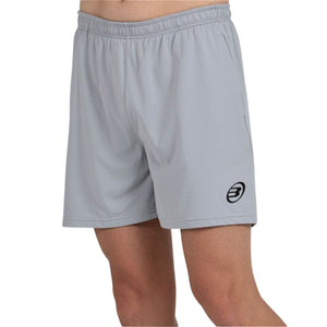 Model draagt de grijze Bullpadel Short Monfort met zwart Bullpadel-logo vooraan