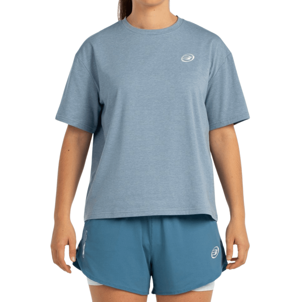 Model draagt het grijsblauwe Bullpadel T-Shirt Oyeme met wit logo op de borst