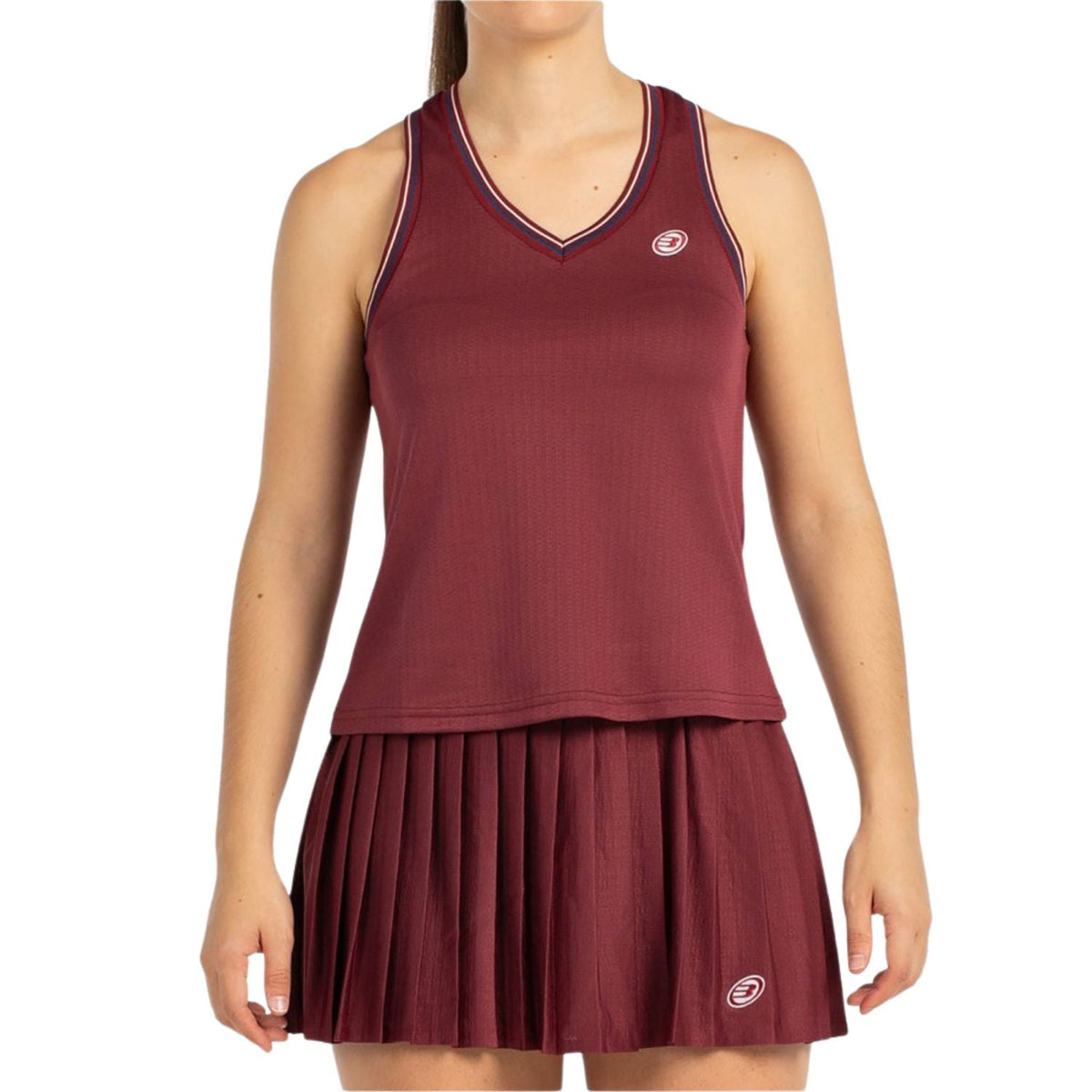 Model draagt de bordeauxrode Bullpadel W Aza tanktop bij een bijpassende plooirok