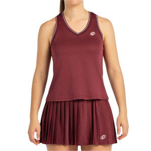 Model draagt de bordeauxrode Bullpadel W Aza tanktop bij een bijpassende plooirok