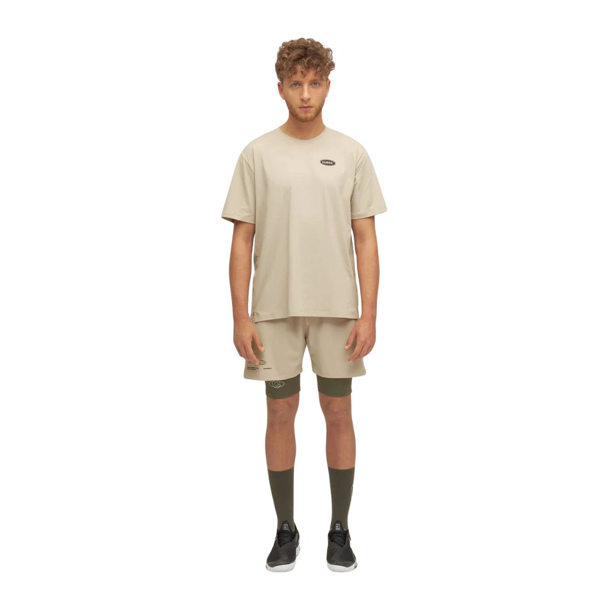 Model draagt de olijfgroene Cuera Active Globe short met beige T-shirt, volledig beeld