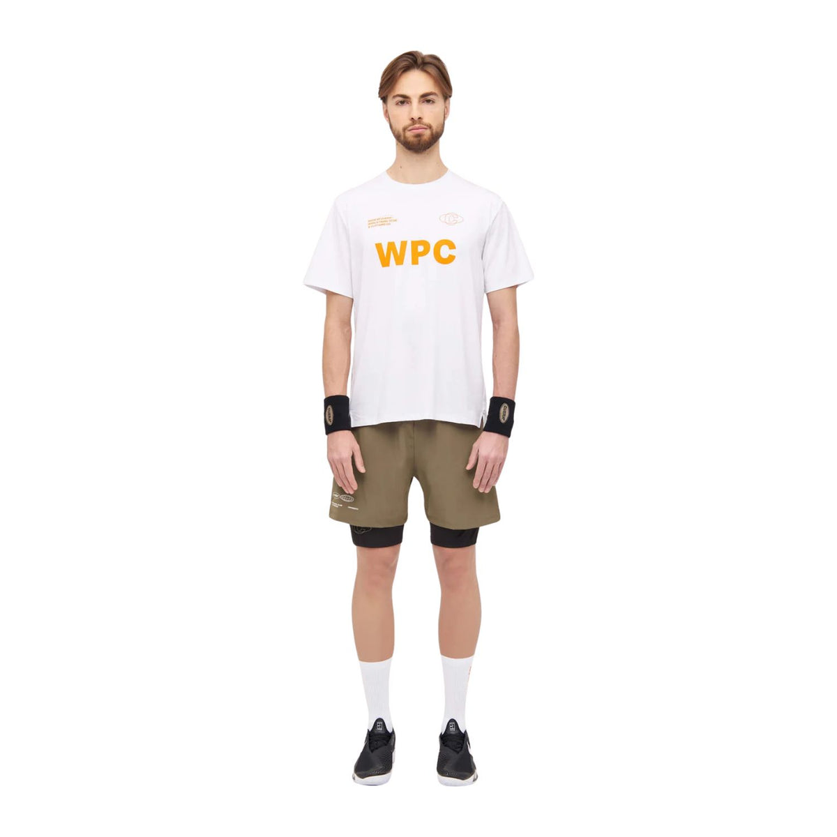 Model draagt de olijfgroene Cuera Active Globe short met wit WPC T-shirt en polsbandjes