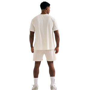 Achteraanzicht van een model in het gebroken witte Cuera WPC T-shirt en short