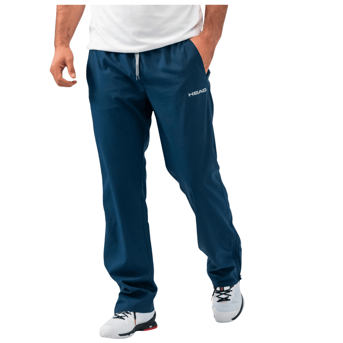 Model draagt de donkerblauwe Head Club Pants met witte sneakers, onderlichaam in beeld