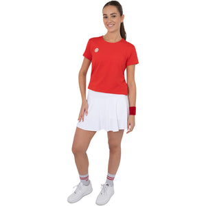 Model ten voeten uit in het rode Breeze T-shirt en witte tennisrok