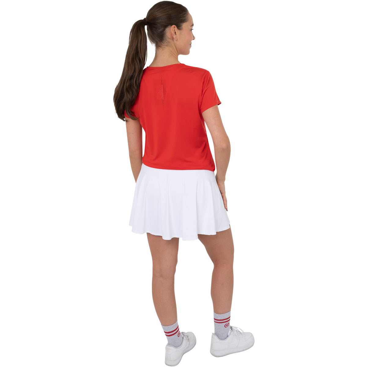Achteraanzicht van model in het rode Breeze T-shirt en witte rok