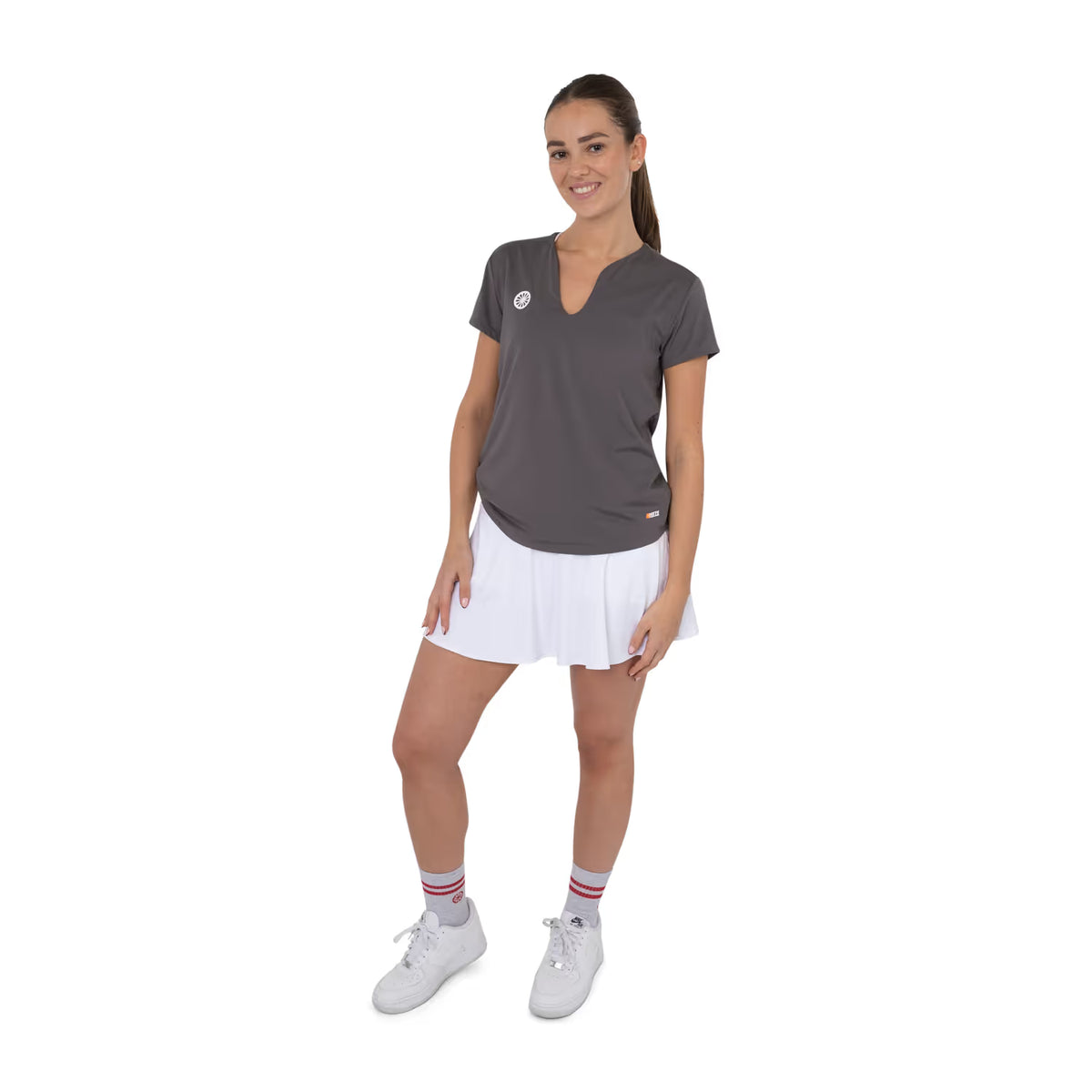 Model draagt het taupegrijze Breeze T-shirt met witte tennisrok