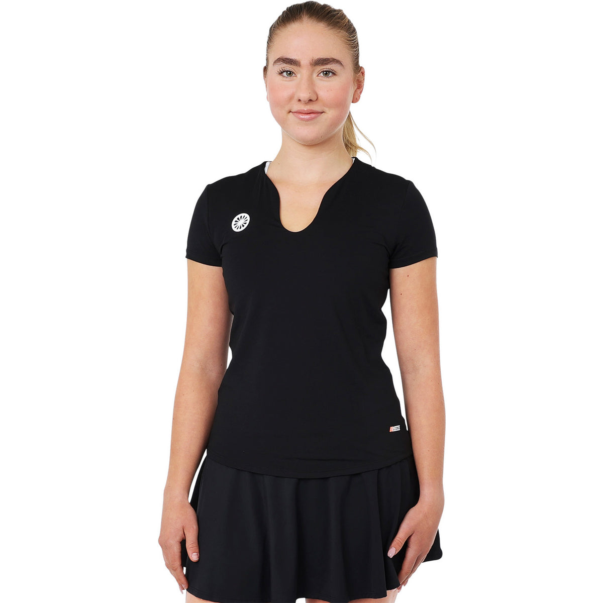 Model draagt het zwarte Breeze T-shirt met zwarte tennisrok