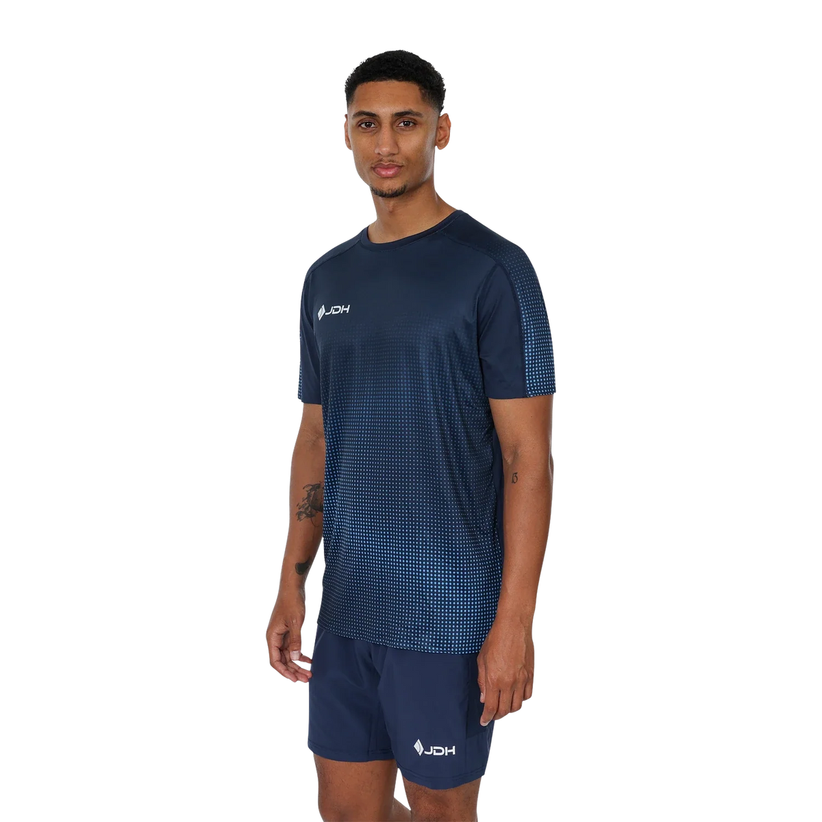 Model draagt de complete JDH Graphic T-Shirt Navy set: marineblauw shirt met stippenprint en marineblauwe short