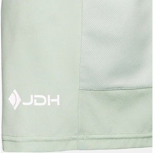 Detail van het witte JDH-logo op de JDH Performance Short Sage
