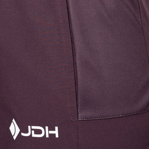 Detail van de zijzak en het JDH-logo van de aubergine Performance short