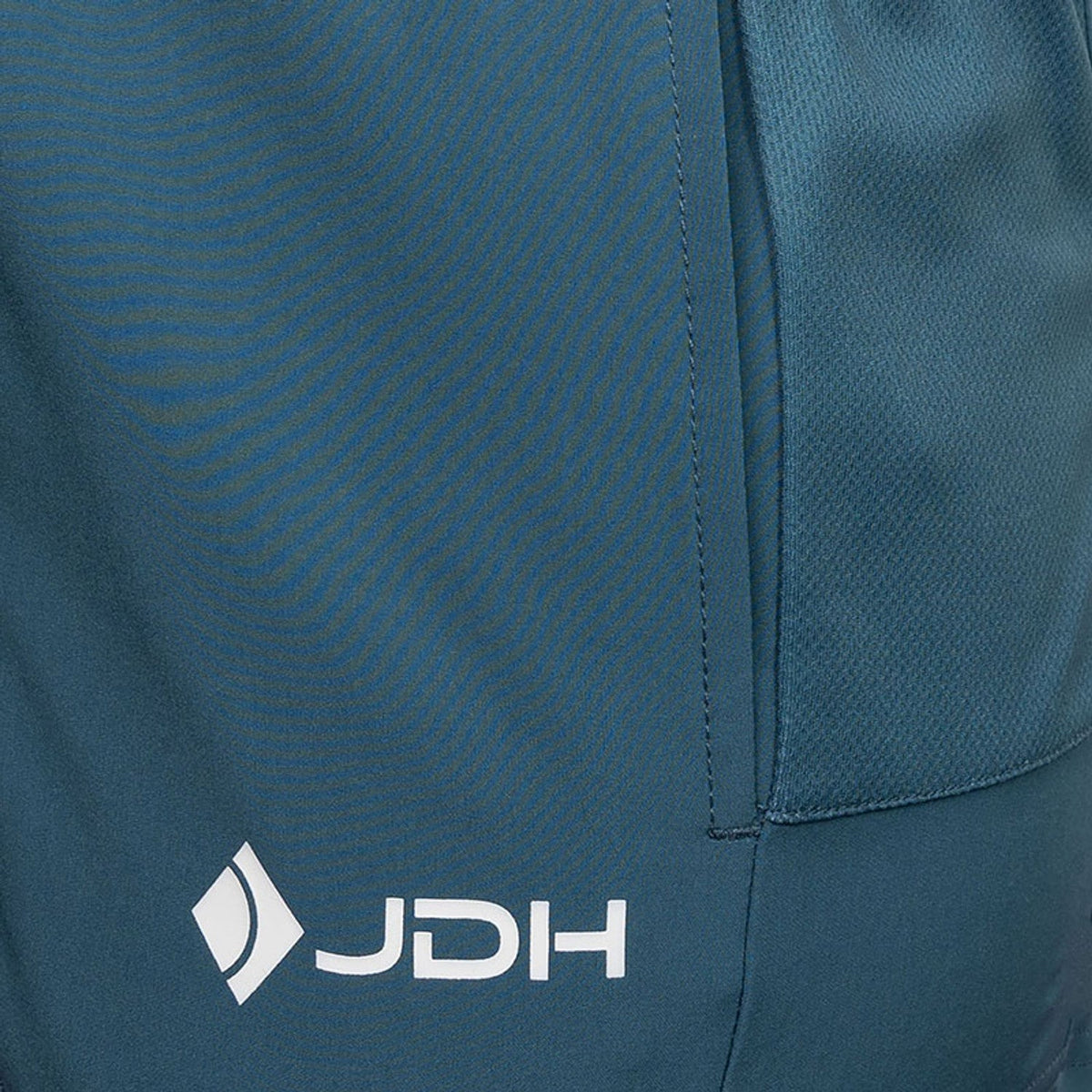 Detail van de zijzak en het JDH-logo van de petrolblauwe Performance short