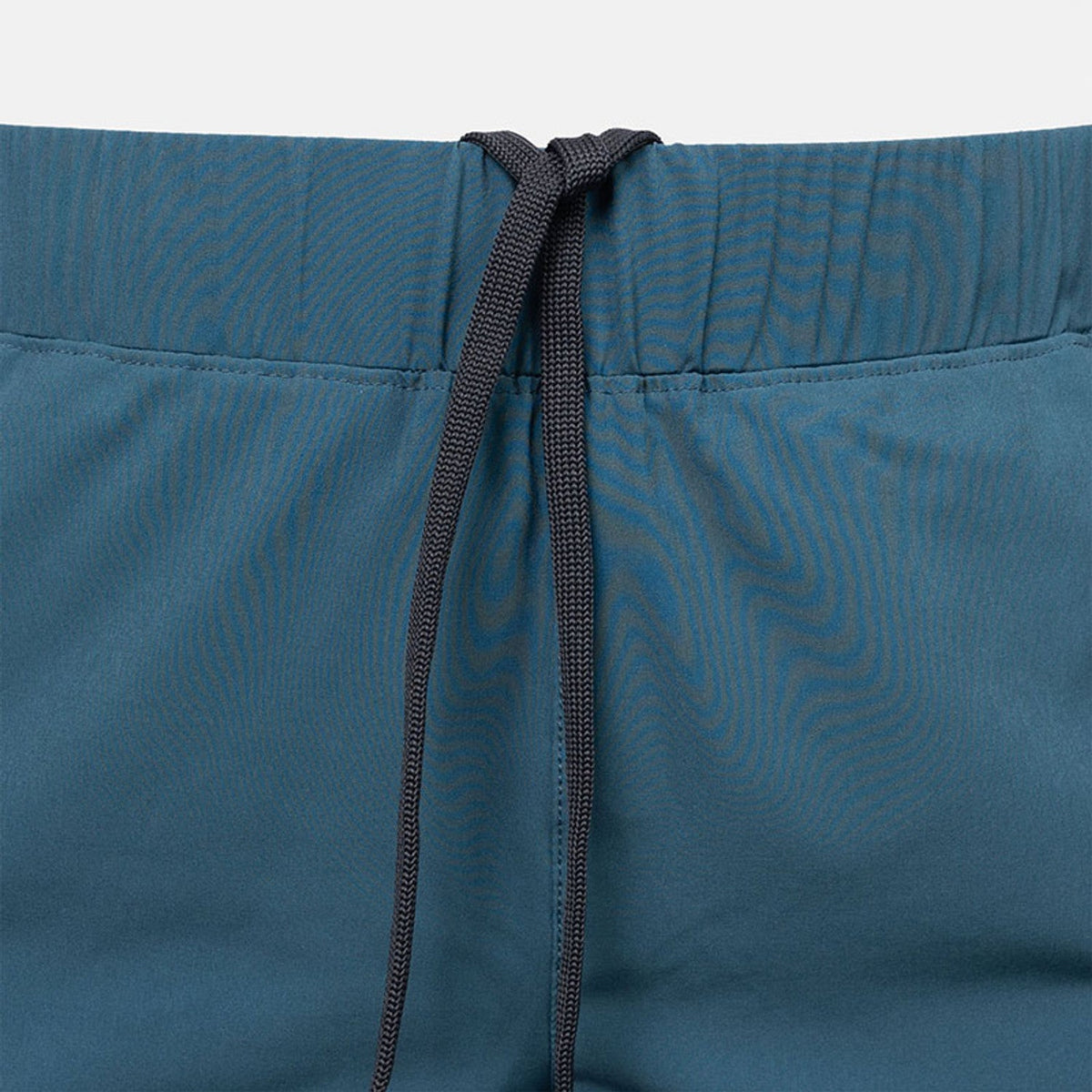 Detail van de tailleband met trekkoord van de petrolblauwe Performance short