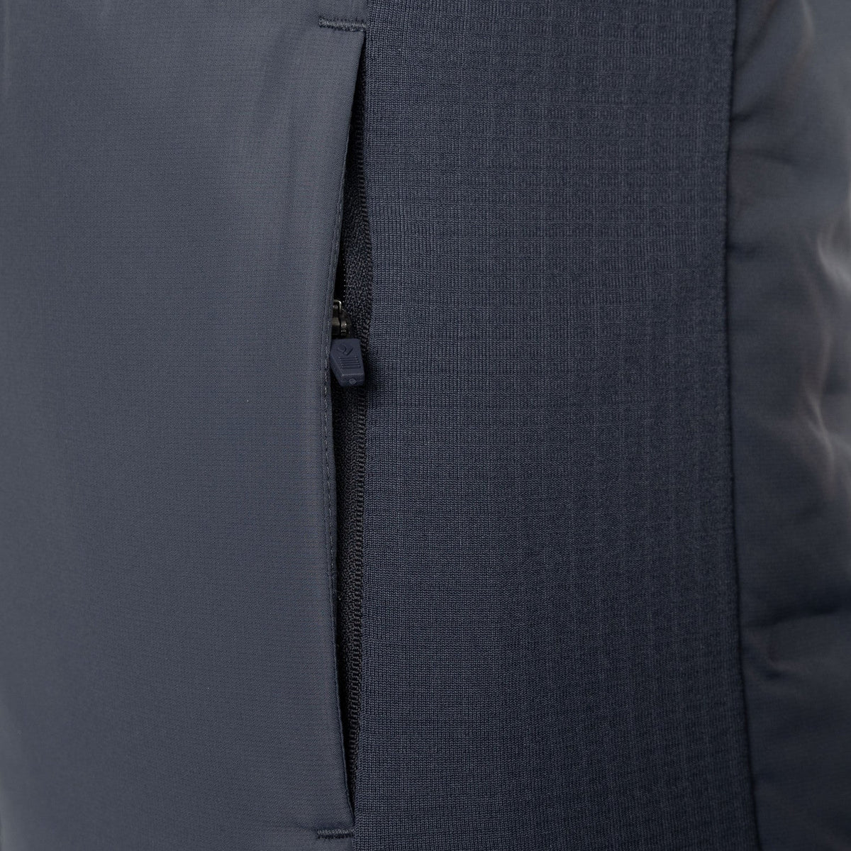 Detail van de ritszak en het gewatteerde paneel van de grijze JDH W Hybrid Padded Gilet