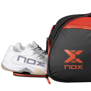 Geopend schoenenvak van de zwart-rode Nox Luxury met een paar witte sportschoenen