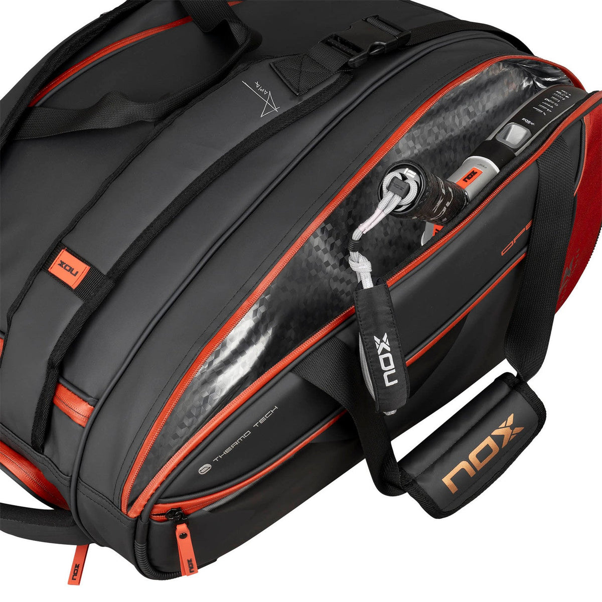 Geopende zwart-rode Nox Luxury racketbag met accessoires en sleutels in het zijvak