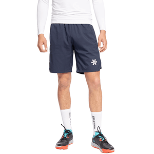 Model draagt de donkerblauwe Osaka Men Training Short met wit shirt en padelschoenen