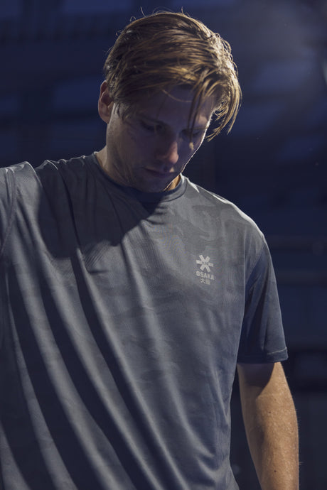 Sfeerfoto van een speler in het Osaka T-Shirt Training in gedempt blauwgrijs licht