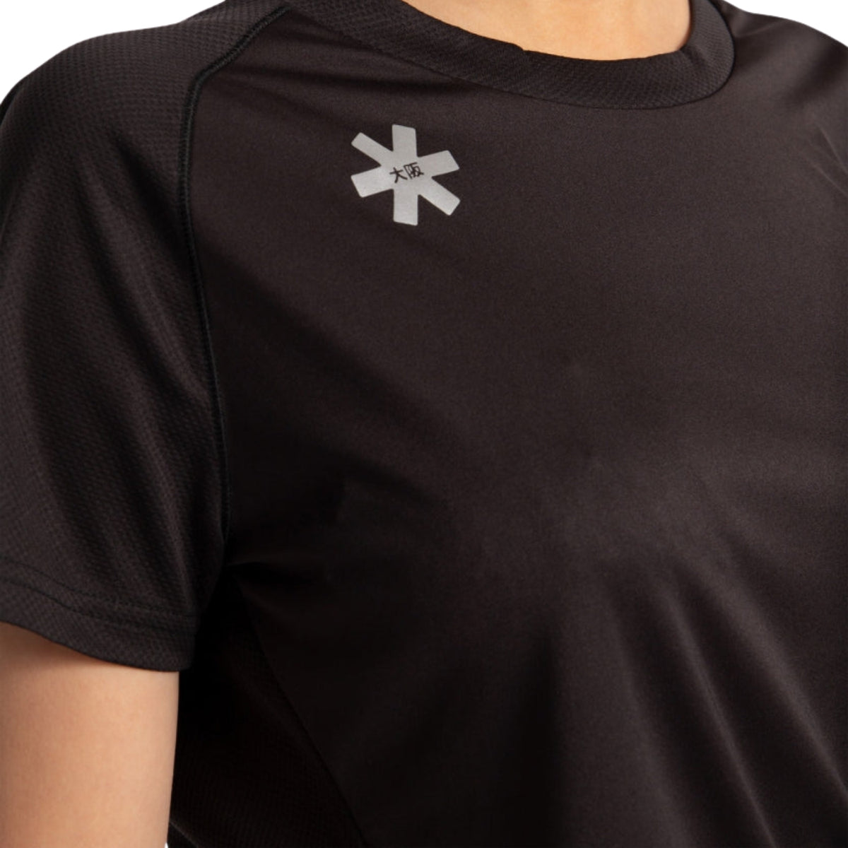 Detail van het Osaka-logo op de schouder van het zwarte Training T-shirt