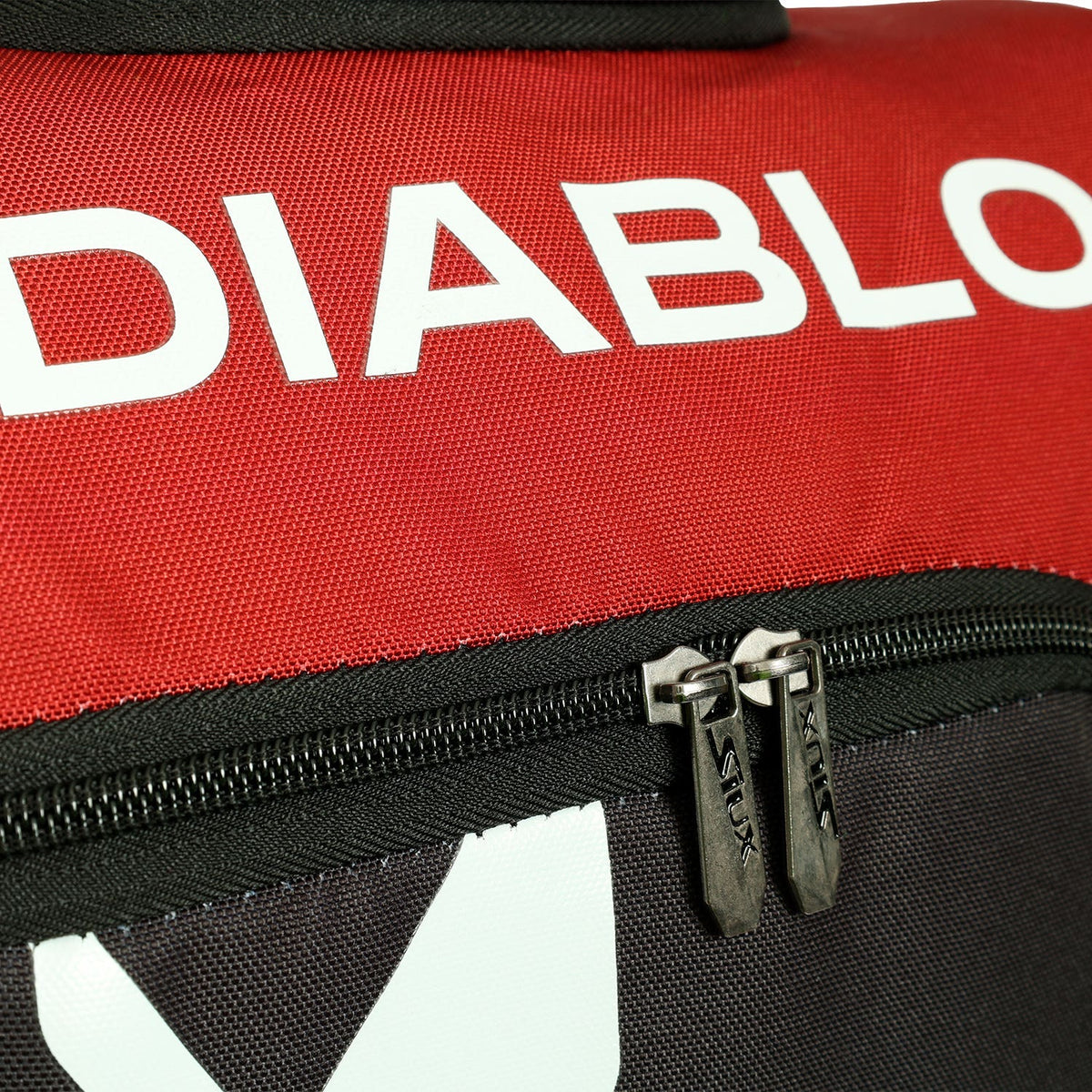 Detail van de witte Diablo opdruk en de dubbele rits van de rode rackettas