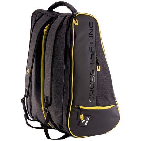 Driekwartaanzicht van de zwarte Siux Trail 2026 racketbag met gele ritsen en draagbanden