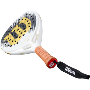 Wilson Defy SE V1 padelracket schuin liggend met bruine grip en polsband