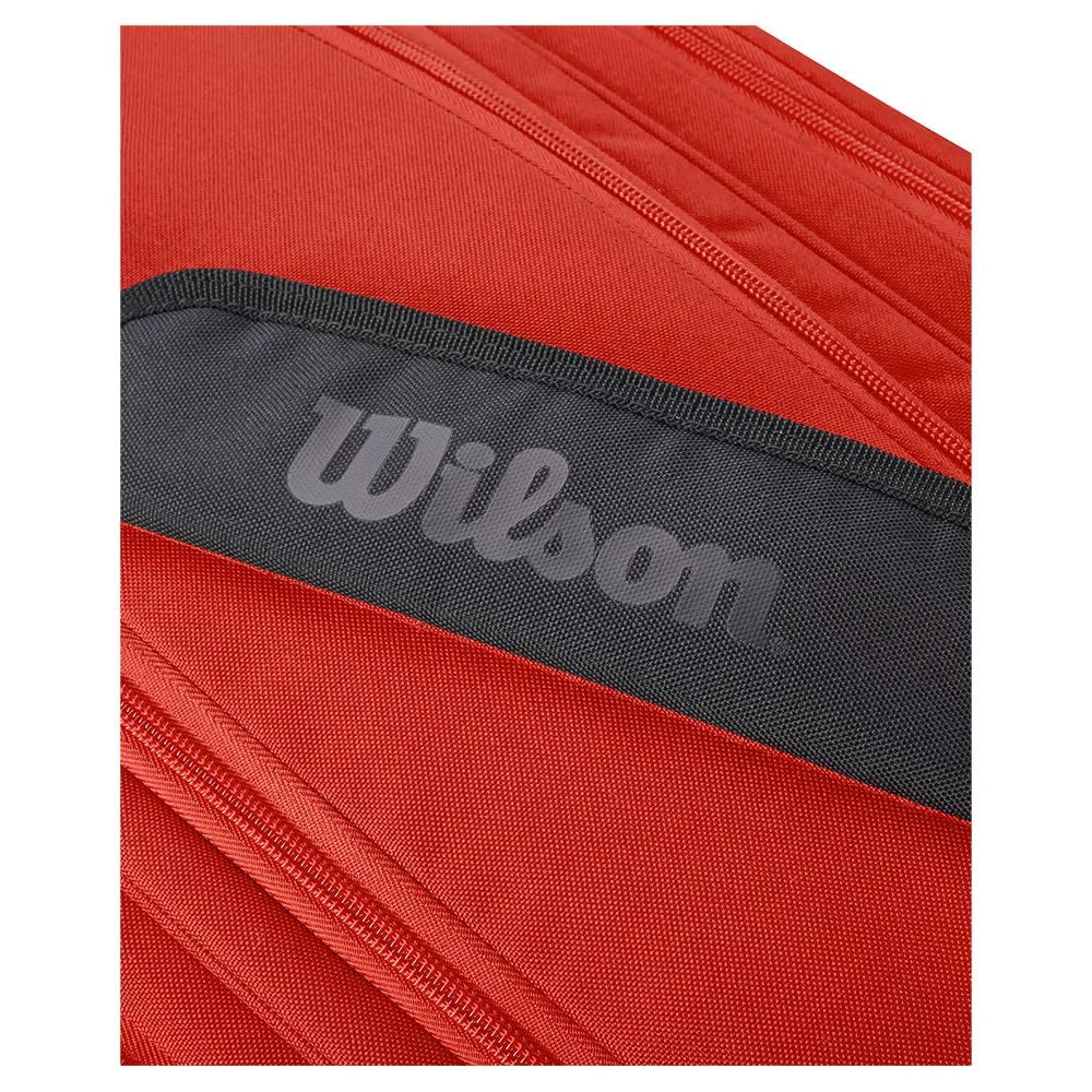 Detail van de grijze Wilson opdruk op de zijkant van de rode rackettas