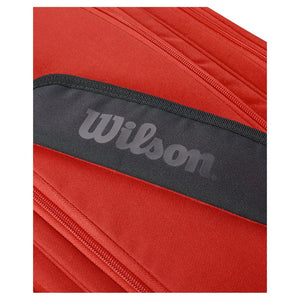 Detail van de grijze Wilson opdruk op de zijkant van de rode rackettas