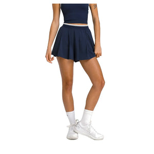 Model ten voeten uit in de donkerblauwe Wilson Velocity plisseshort